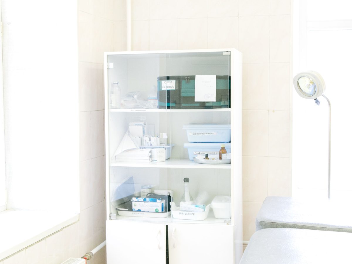 Closed glass storage doors with organised medical supplies inside.